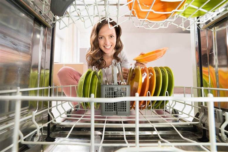 a woman loading a dishwasher