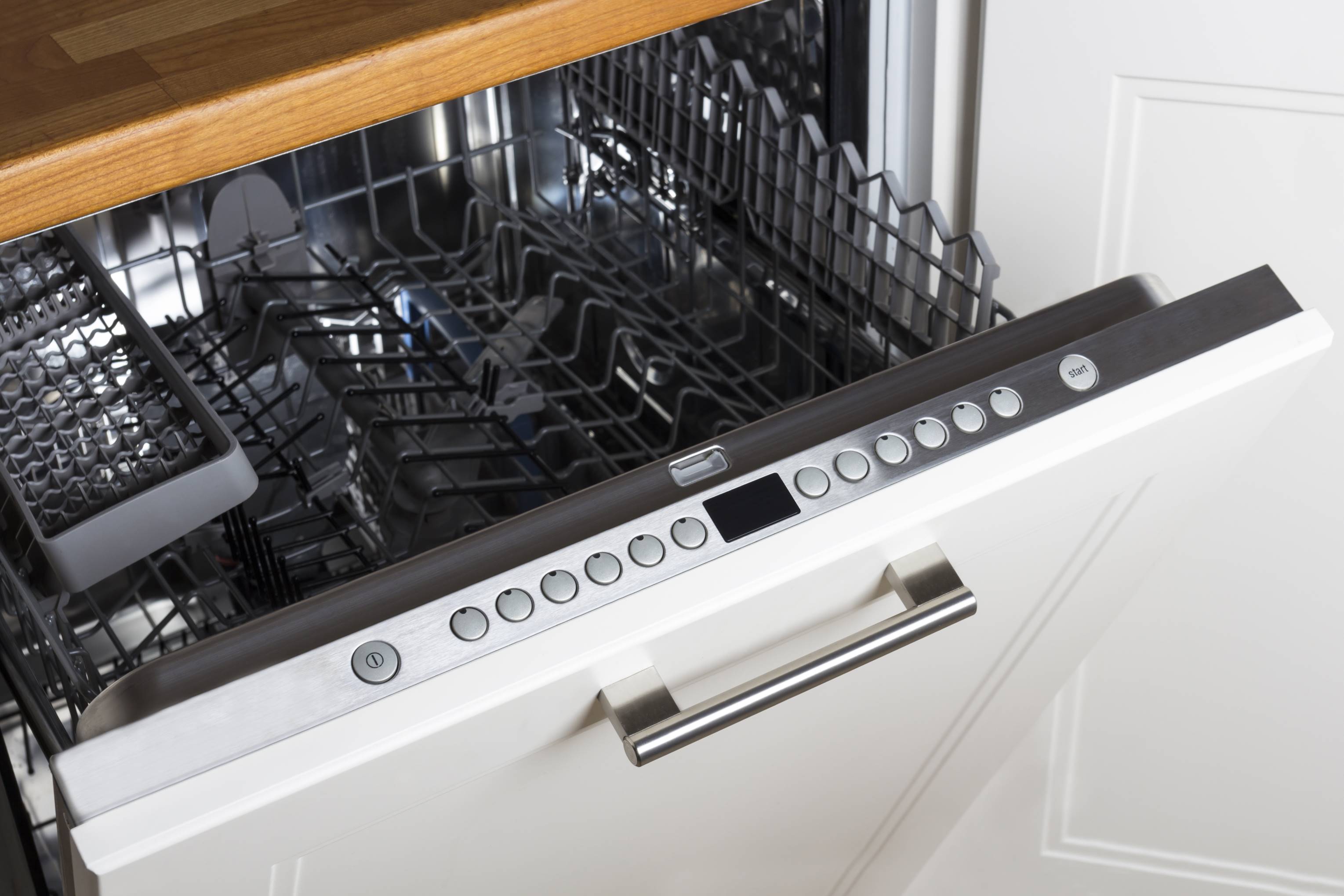 modern half open empty dishwasher in a modern kitchen