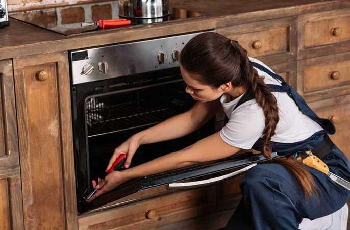 a woman fixing a stove in a wooden kitchen